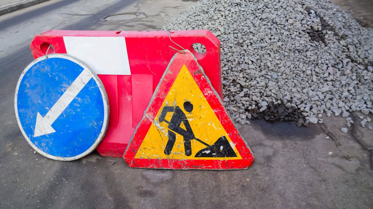 Útépítési munkálatokat jelző közlekedési táblák az út szélén.