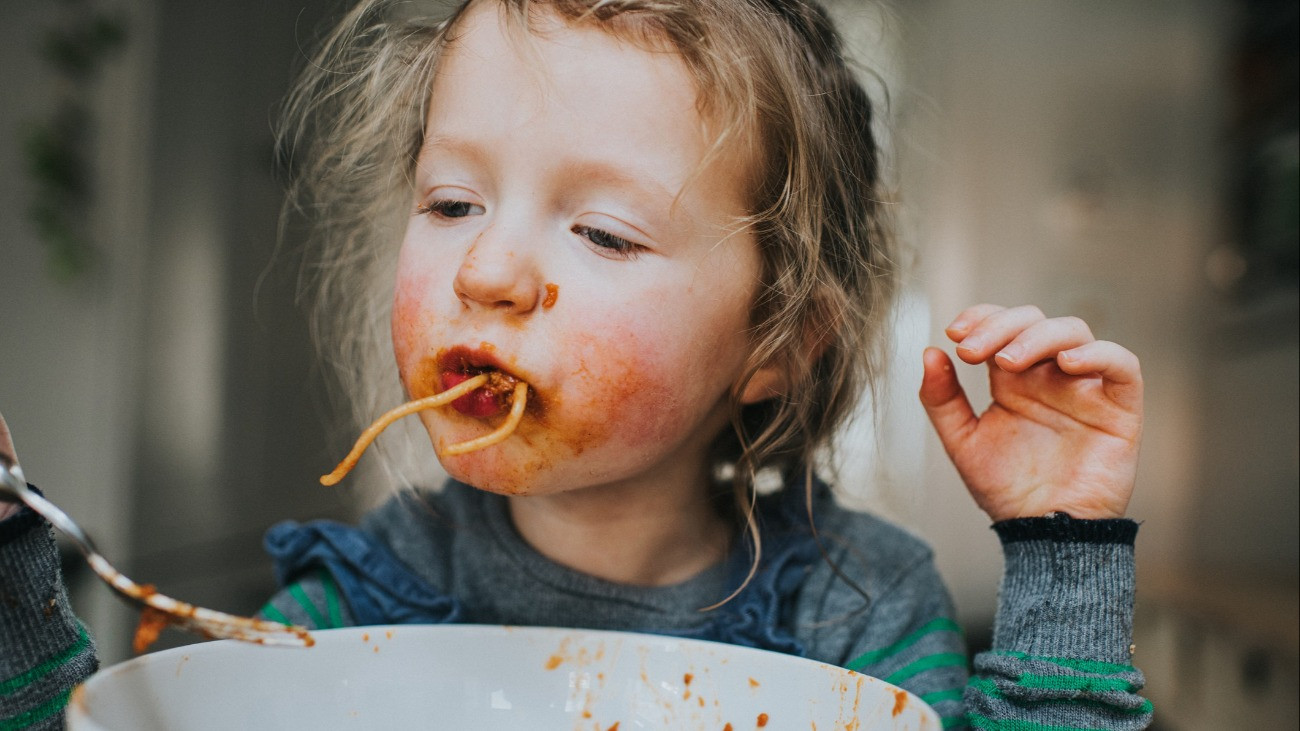 Kislány eszi az ebédjét.