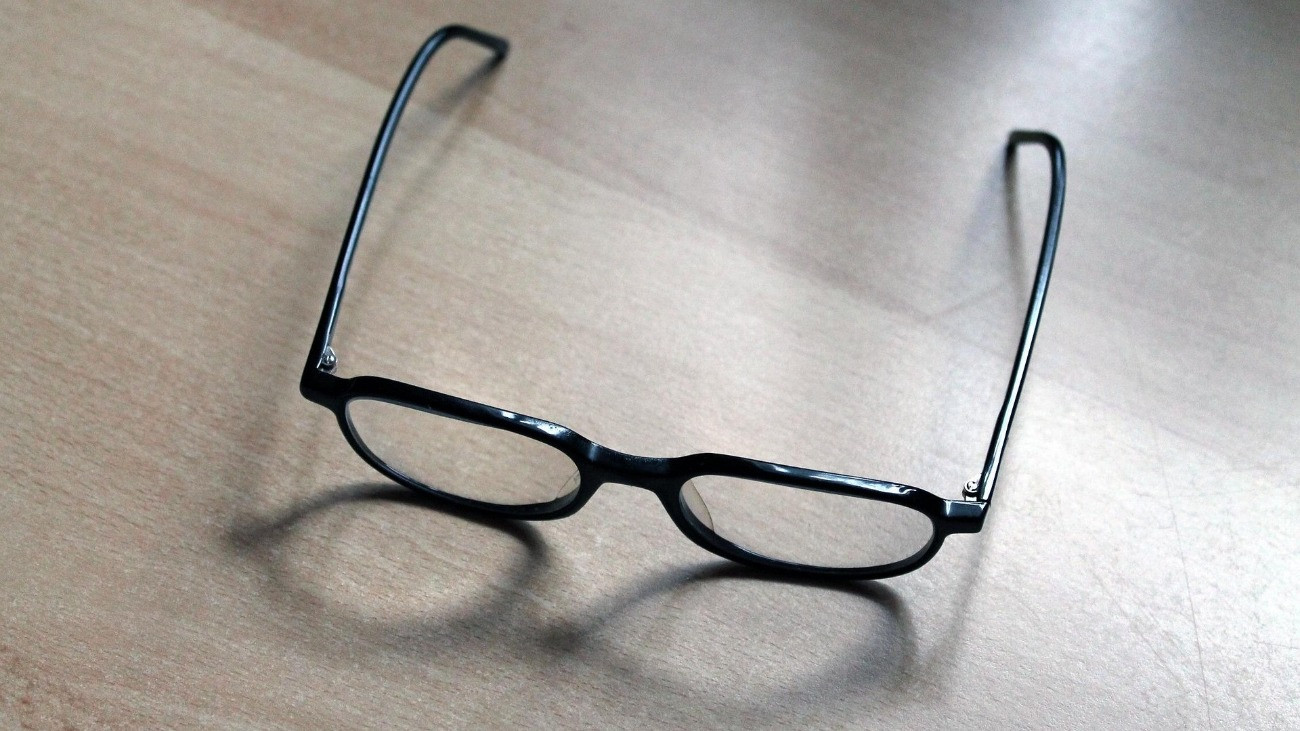 fekete keretes szemüveg egy asztalon