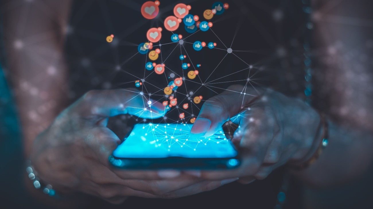 Fiatal nő egy okostelefonon a közösségi médiát böngészi.