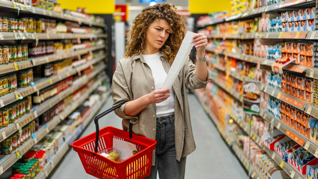 Aggodalmas fiatal nő egy élelmszerboltban.