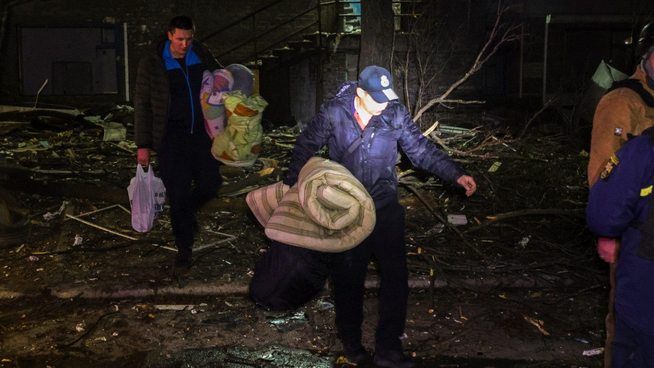Embereket evakuálnak megrongálódott otthonukból egy orosz légitámadásban találatot kapott lakóépületnél a délkelet-ukrajnai Zaporizzsjában 2025. november 26-án.