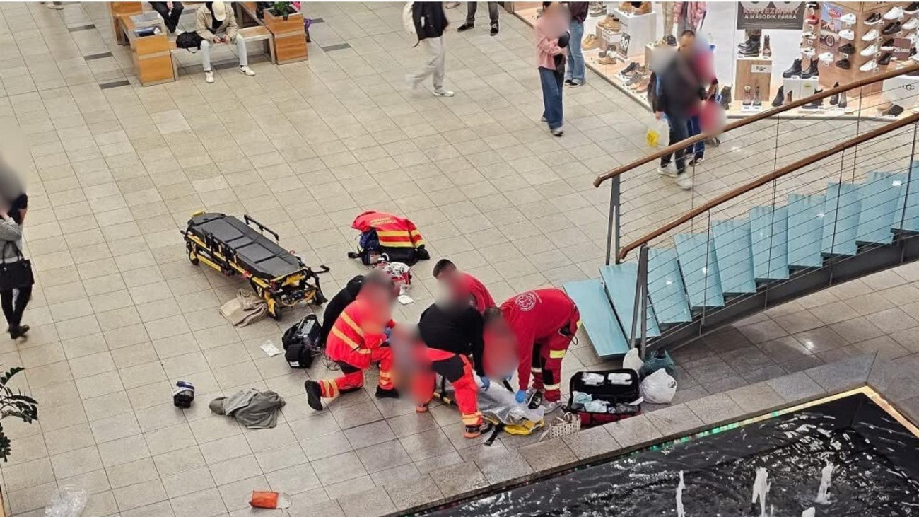 A Debreceni Mentőállomás munkatársai egy eszméletlen férfit kezelnek egy bevásárlóközpontban.