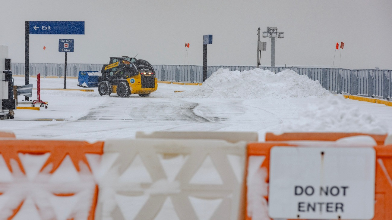 A skid steer loader clears snow from a parking garage at OHare International Airport (ORD) during a snowstorm in Chicago, Illinois, US, on Saturday, Nov. 29, 2025. Hundreds of flights have been canceled in and around Chicago and roads are becoming treacherous as one of the busiest travel weekends of the year collides with a major storm bringing wintery conditions throughout the US Midwest Saturday. Photographer: Jim Vondruska/Bloomberg via Getty Images