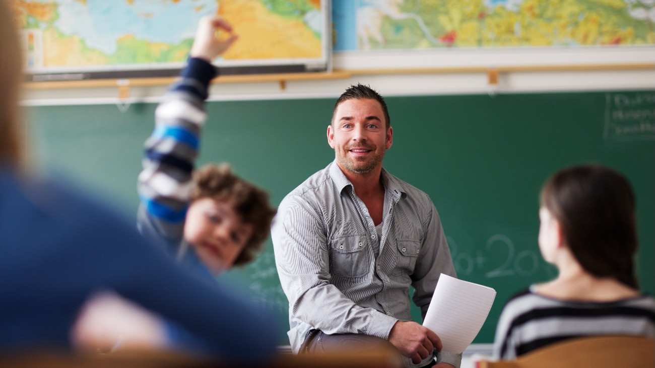 Tanár a tanteremben és egy jelentkező diák.