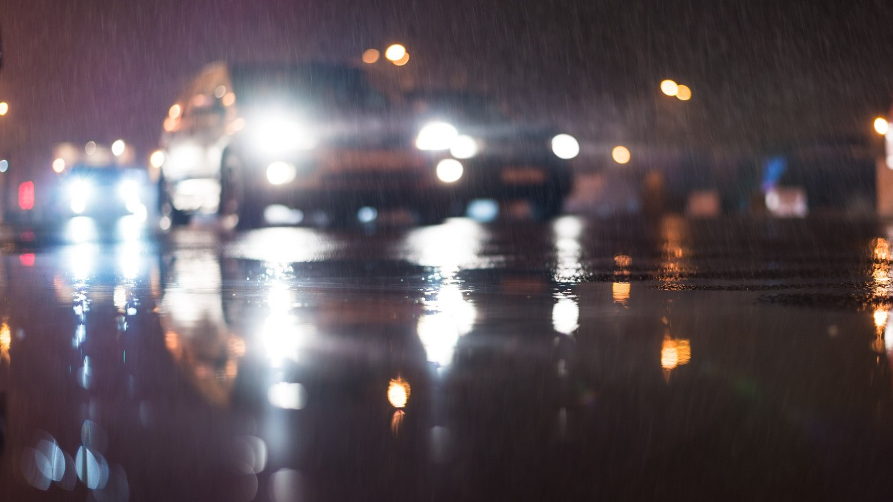 Autók az esős városi éjszakában.