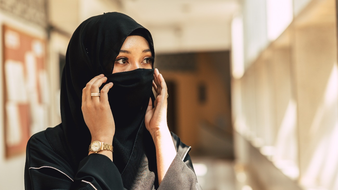 Egy arcot eltakaró nikábot viselő fiatal muszlim nő.