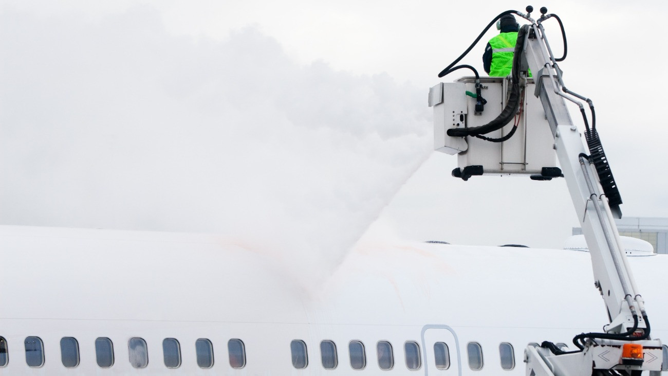 Jégmentesítő folyadékkal permeteznek felszállás előtt egy repülőgépet.