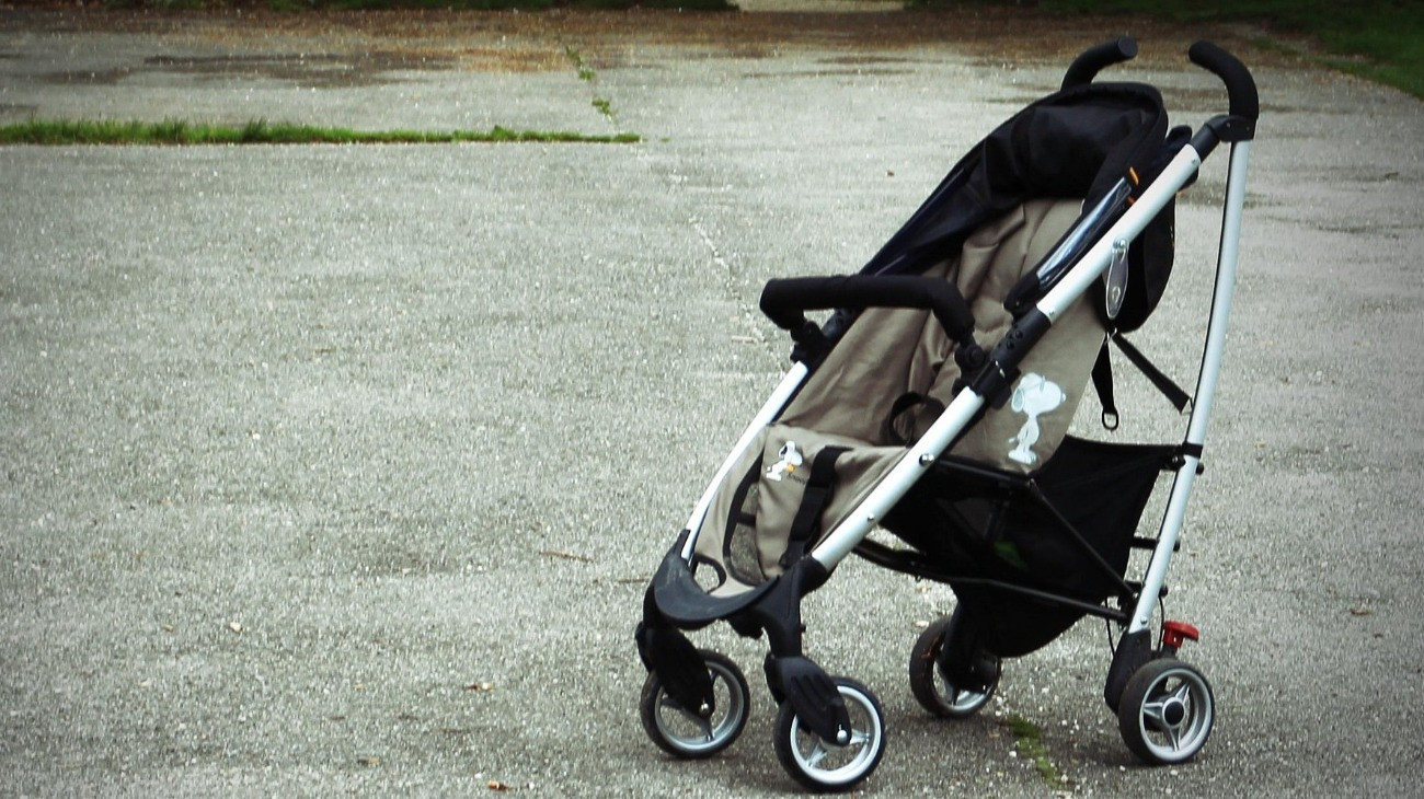 Babakocsi, baba nélkül, Snoopy-kutyás díszítéssel.