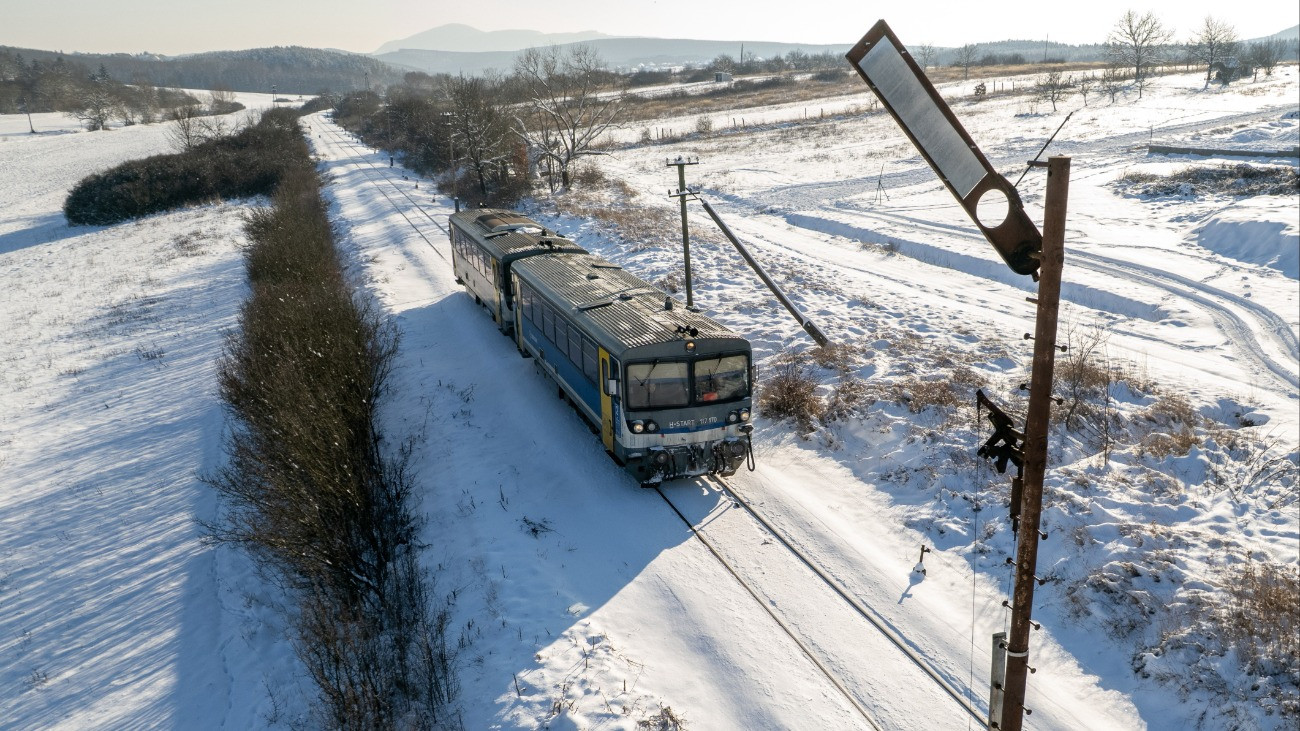 A drónnal készült felvételen személyvonat érkezik a behavazott nógrádi vasútállomásra 2026. január 8-án.